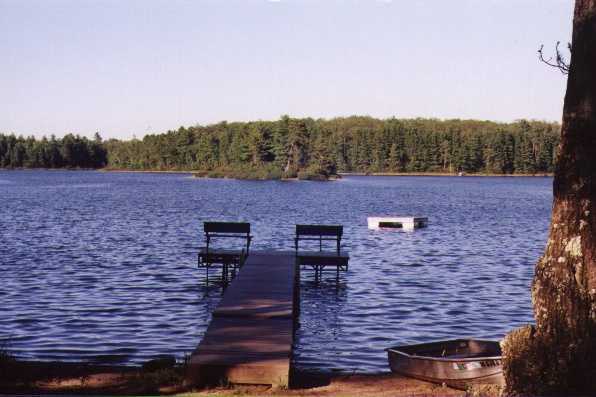 Jag Lake with dock, raft, boat, and view of wooded coastline