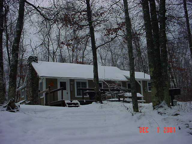 photo exterior of cabin in winter with snow