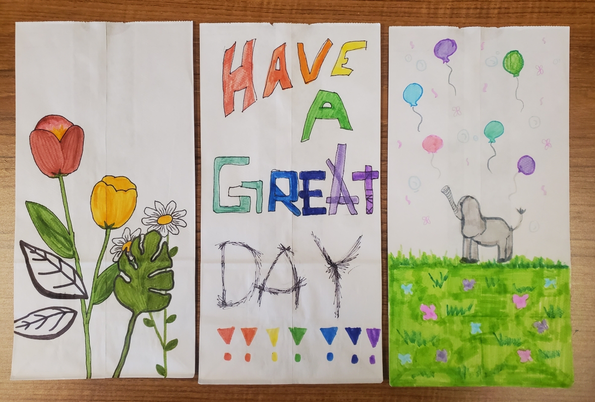 lunch bag art by Eagle School middle schoolers, including a beautiful sunflower, and a very happy elephant with its trunk in the air