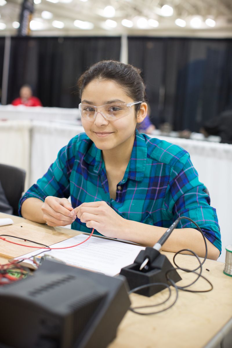 High School girl soldering at competitive event