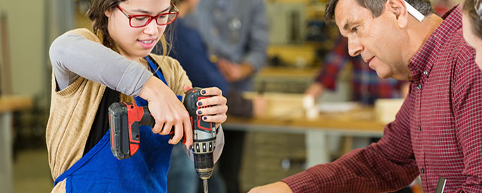 female student using electric hand drill