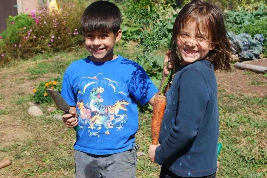 kids with veggies and garden tools