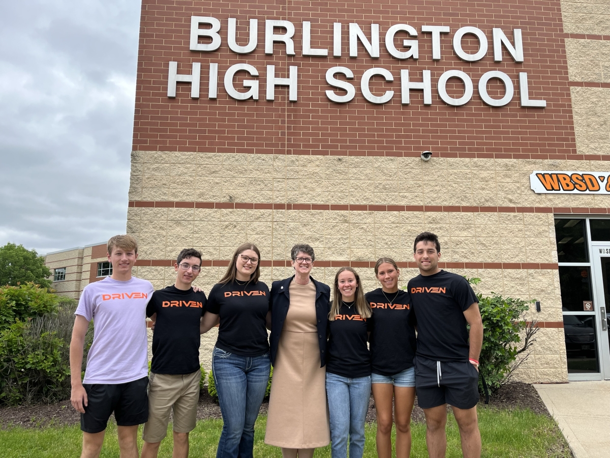 Dr. Underly poses with students from Burlington High School in front of their building.