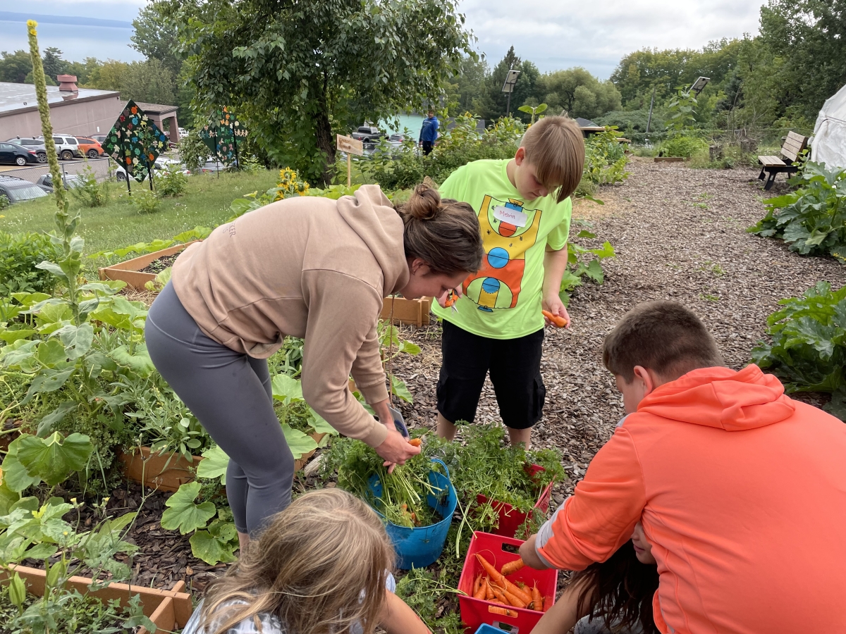 Children with an AmeriCorps Farm to Table leader in a school garden