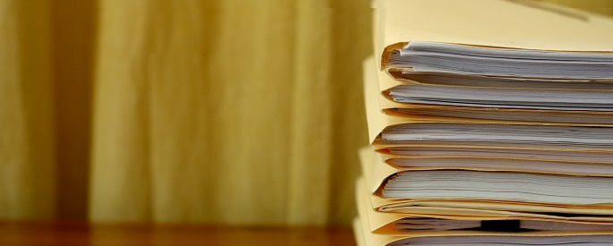 Stack of manila folders with paperwork inside