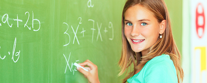 female student doing math at chalkboard