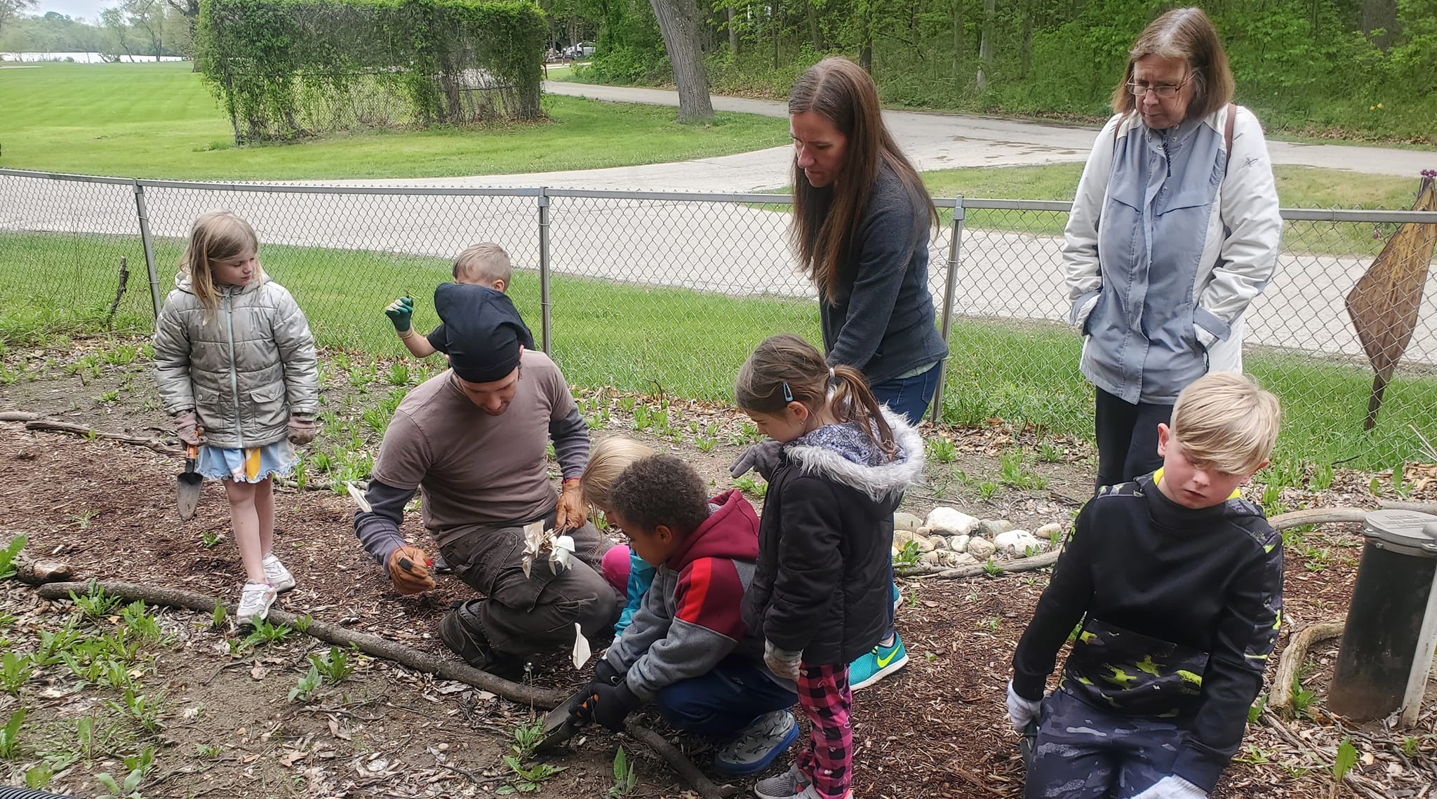 Primary grade students and a local landscaper expand the  butterfly garden.