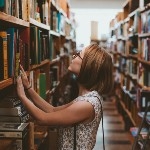Girl leaning on book shelf